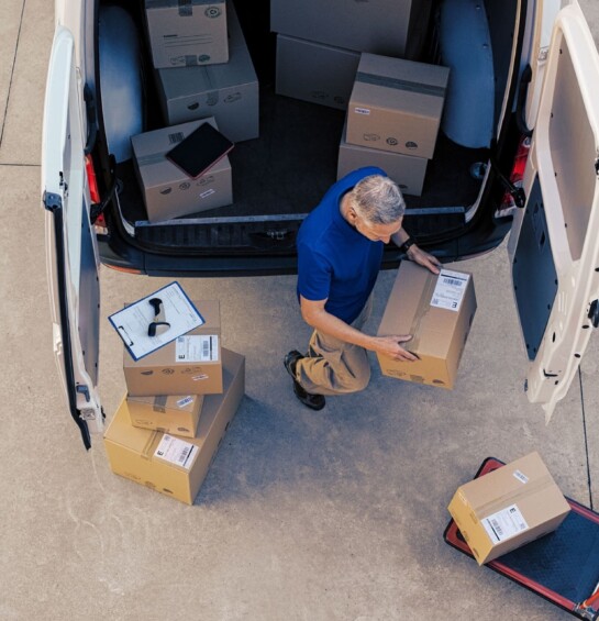 A man loading boxes into the back of a van.