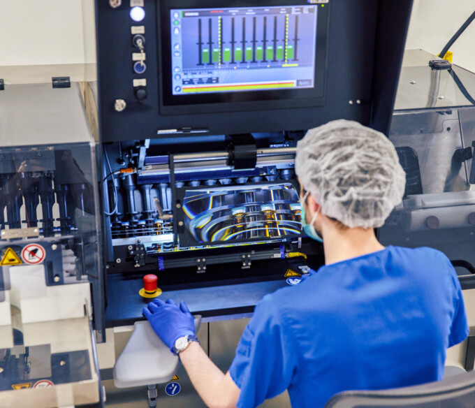 A person in blue scrubs operating machinery.