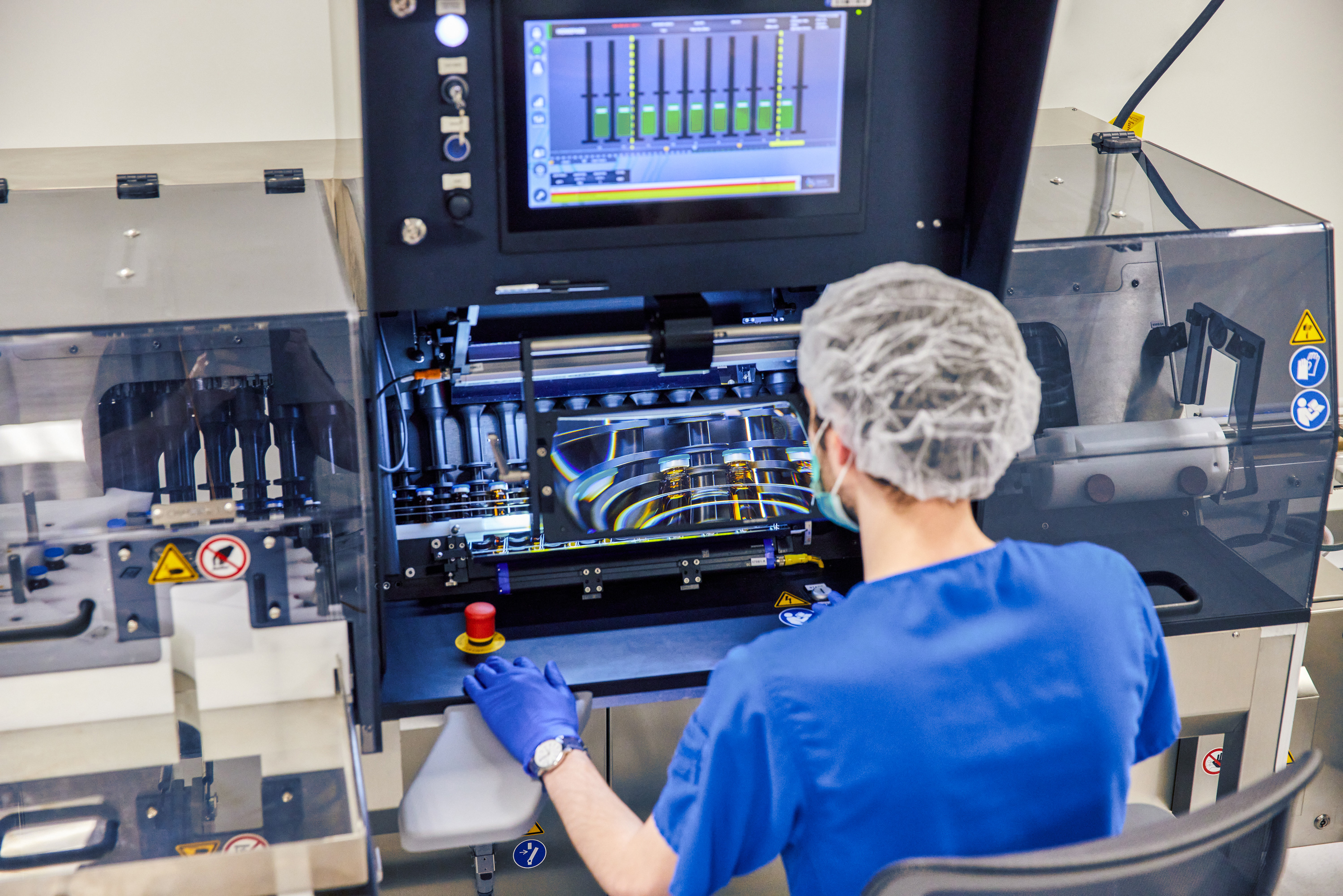 A person in blue scrubs operating machinery.