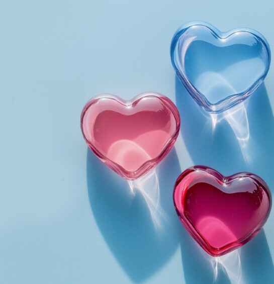 blue background with 3 glass looking hearts, in light blue, pink and magenta