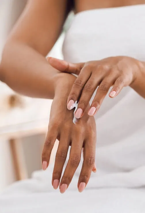 Woman's hands applying hand cream.