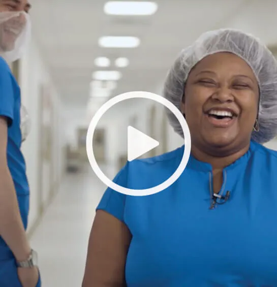 Woman in a blue shirt laughing.